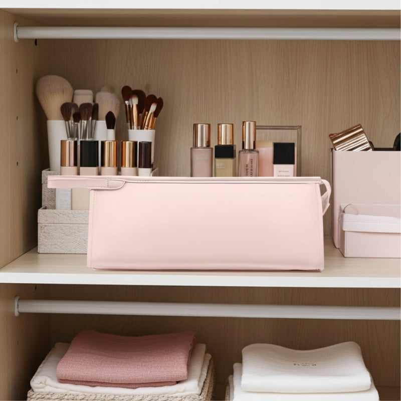Makeup brushes and products with a hair dryer case on a shelf in a well-organized closet.