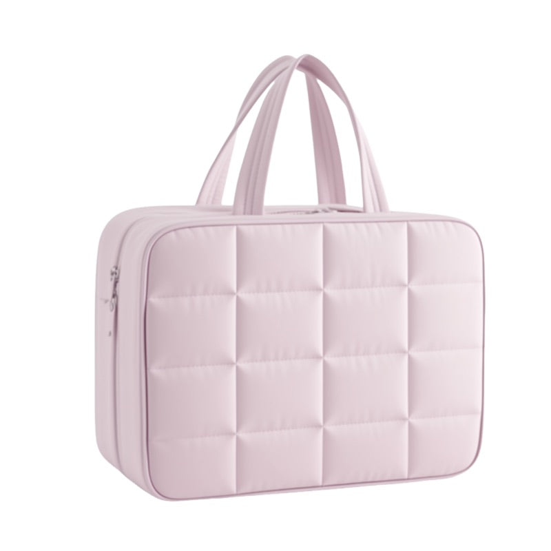 Pink quilted handbag on a white background