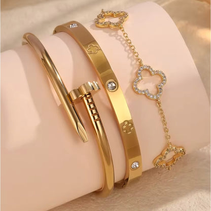 Gold bracelets with heart-shaped charms on a soft pink background