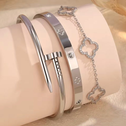 Two silver bracelets with heart-shaped charms on a beige background