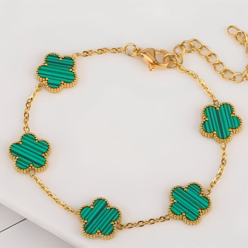 Gold bracelet with green clover-shaped charms on a white background