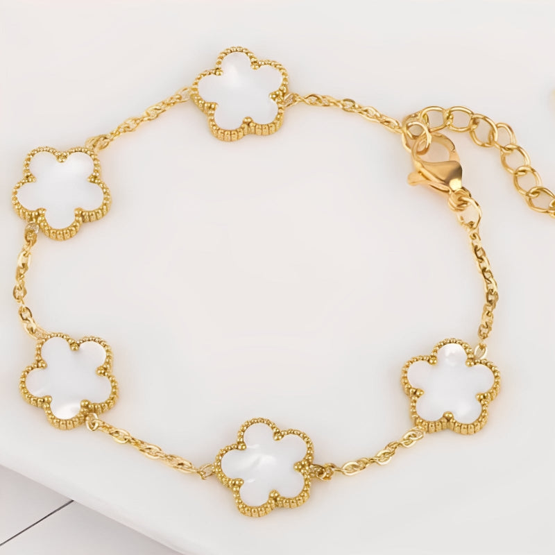 Gold bracelet with clover-shaped links on a white background
