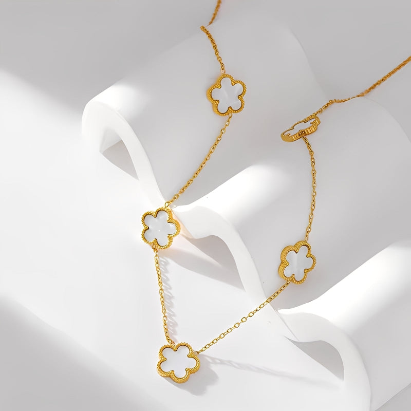 Gold necklace with clover-shaped pendants on a white background
