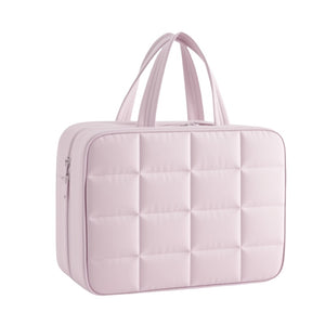 Pink quilted handbag on a white background